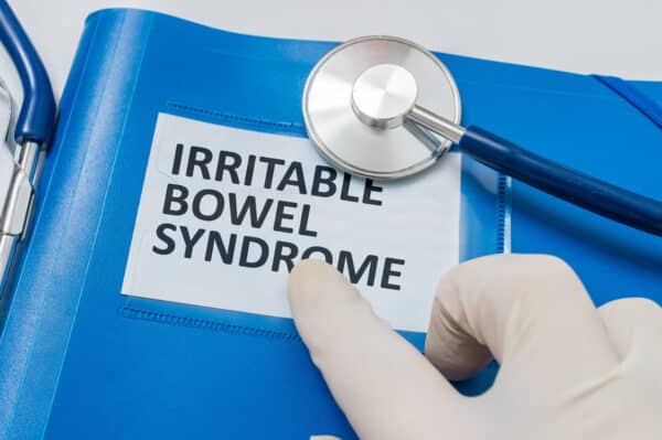 Blue folder with patient files with IBS (Irritable Bowel Syndrome) diagnosis.